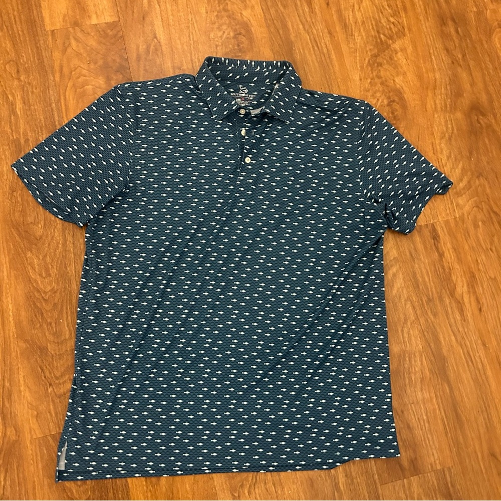 Southern Tide blue all-over print performance polo in a preppy fish pattern